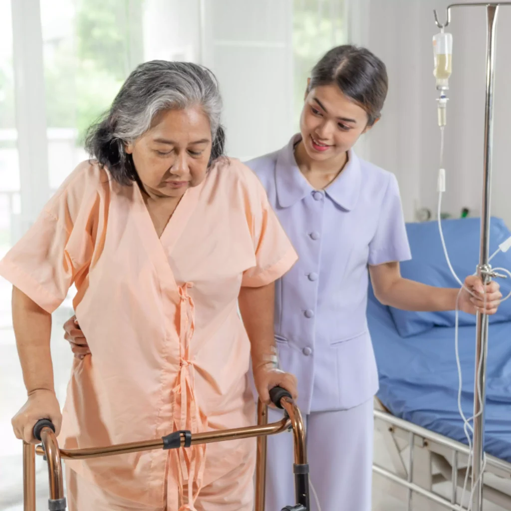 A nurse assisting an elderly woman with a walker in Ranchi, providing nursing care services, elderly care at home