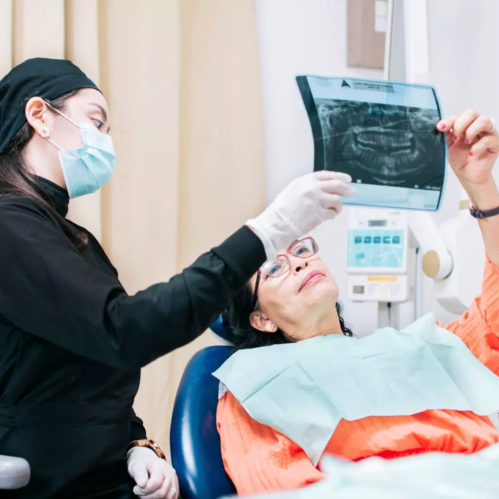 Female patient viewing x-ray in dental chair, image taken at home in Ranchi. x ray at home , x ray services at home in ranchi