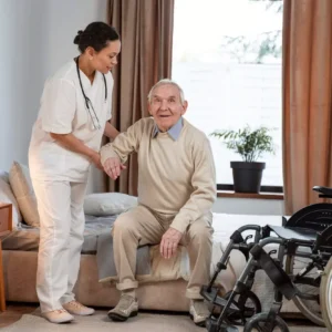 A nurse provides nursing services at home in Ranchi, assisting an elderly man in a wheelchair. elderly care at home घर पर बुज़ुर्गों की देखभाल