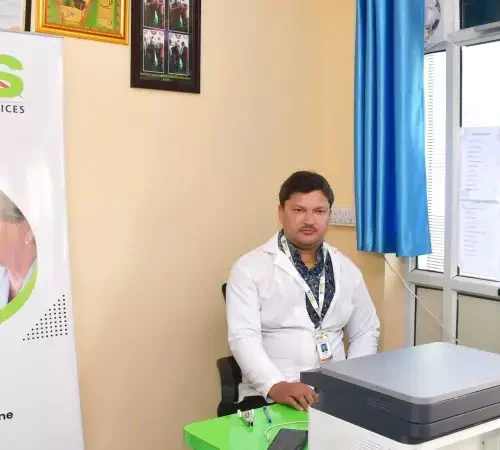 A man sitting at a desk in front of a computer, co-founder of RPCS Nursing agency, offering home nursing care services in Ranchi